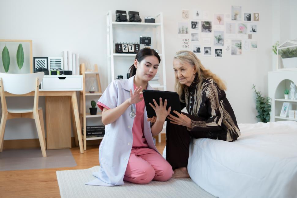 in home health care worker working with elderly woman in bedroom